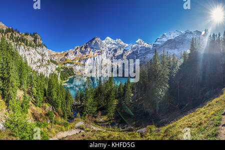 Amazing tourquise Oeschinnensee with waterfalls, wooden chalet and Swiss Alps, Berner Oberland, Switzerland. Stock Photo