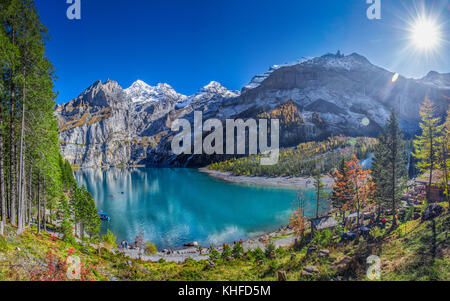 Amazing tourquise Oeschinnensee with waterfalls, wooden chalet and Swiss Alps, Berner Oberland, Switzerland. Stock Photo