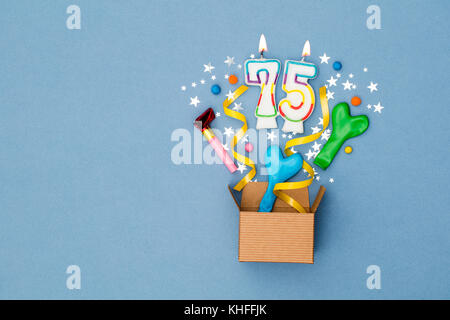 Number 75 celebration present background. Gift box exploding with party decorations Stock Photo