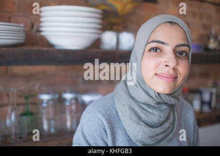 Muslim businesswoman wearing a hijab in her kitchen Stock Photo