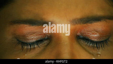 Eye close, Closeup of girl crying with tear rolling down her cheek, Closeup of crying girl face Stock Photo