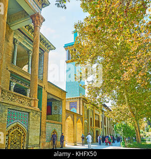 TEHRAN, IRAN - OCTOBER 11, 2017: The walk along the shady alley in Golestan garden with a view on Emarat-e Badgir (Wind Towers Building), on October 1 Stock Photo