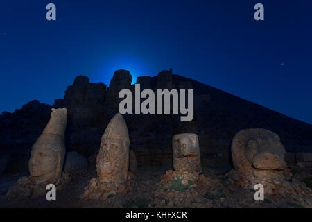 Statues on the Mt Nemrut at the twilight, with the moonlight behind the statues, in Adiyaman, Turkey. Stock Photo