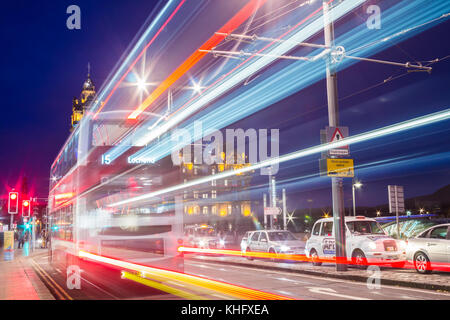 Bus light trails on Princes street in Edinburgh with Balmoral Hotel in background. Scotland. UK Stock Photo