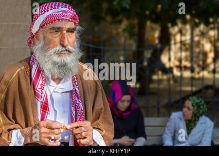 Local man in traditional dresses plays with his prayer beads in Sanliurfa, Turkey Stock Photo