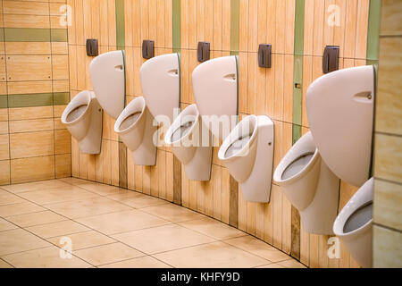 Close up row of urinals men public toilet Stock Photo