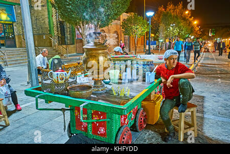 TEHRAN, IRAN - OCTOBER 11, 2017: The boy sells traditional Persian hot tea, boiled in samovar from the wooden cart in Bab Homayoon street, on October  Stock Photo