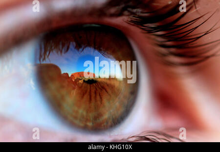 Ayers Rock, Uluru is reflected in the eye of a western tourist at sunset, Uluru-Kata Tjuta National Park, Northern Territory, Australia. Stock Photo