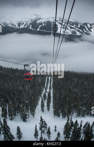 Cable car running between two snow covered mountains at a ski resort Stock Photo