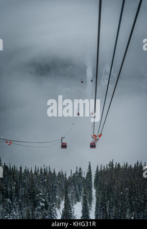 Cable car running between two snow covered mountains at a ski resort Stock Photo