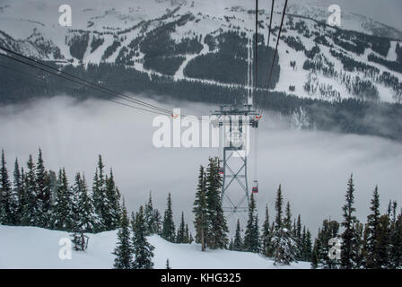 Cable car running between two snow covered mountains at a ski resort Stock Photo