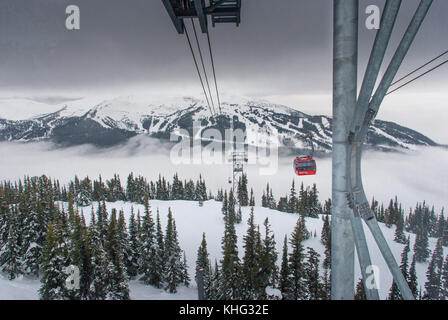 Cable car running between two snow covered mountains at a ski resort Stock Photo