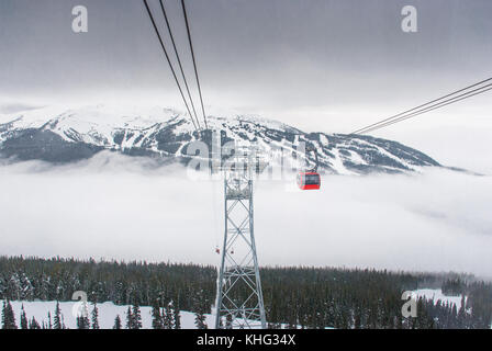 Cable car running between two snow covered mountains at a ski resort Stock Photo