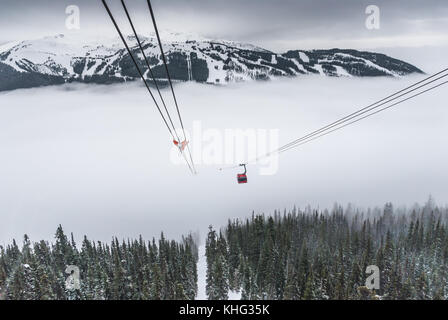 Cable car running between two snow covered mountains at a ski resort Stock Photo