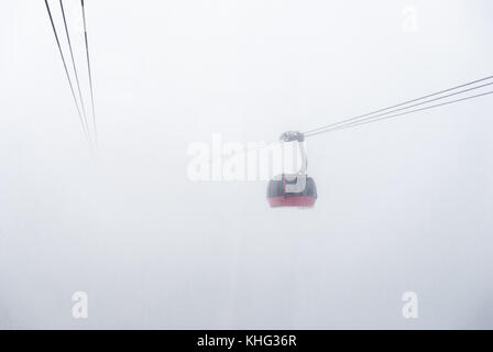 Cable car running between two snow covered mountains at a ski resort Stock Photo