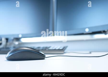 Mouse at a computer with monitors on a desktop Stock Photo