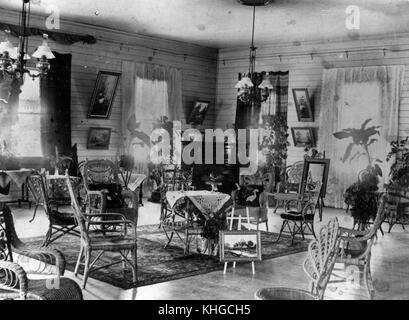 This photograph from around 1895 shows a room furnished with wicker furniture in a residence in Bowen. The image highlights the interior design trends and domestic aesthetics of the late 19th century. Stock Photo