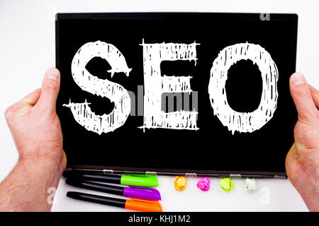 SEO text written on tablet, computer in the office with marker, pen, stationery. Business concept for SEO white background with space Stock Photo