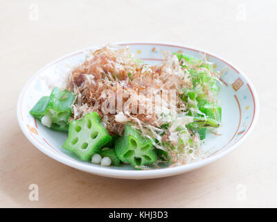 Japanese cuisine, boiled and sliced okura with dried bonito flakes on the wooden table Stock Photo