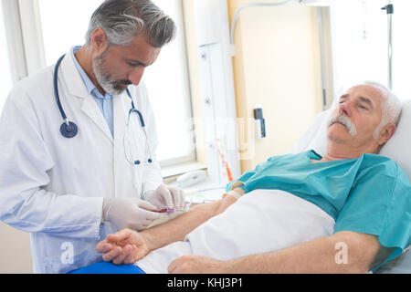 doctor is doing blood test for man in clinic Stock Photo