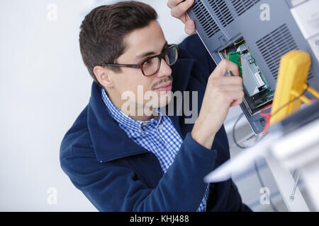 worker in uniform checking quality of processed tool Stock Photo