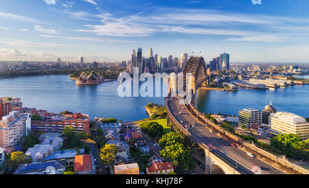 Cahill express way to the Sydney Harbour bridge across Sydney harbour towards city CBD landmarks in aerial eleveated wide view under blue morning sky. Stock Photo