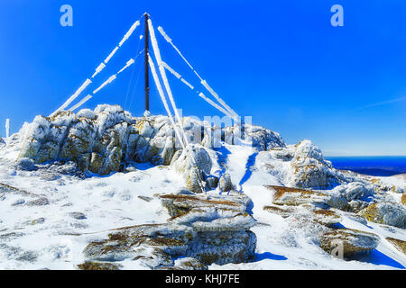 Back Perisher mount top in Snowy mountains national park in Winter with peak top mast, cables and antennae covered in ice and snow. Stock Photo