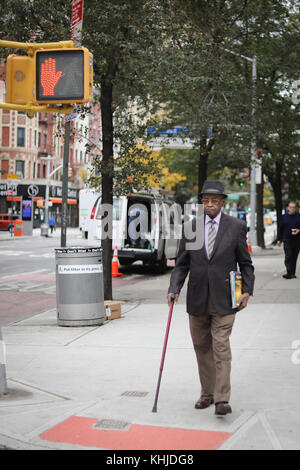 NEW YORK CITY, NY, USA - OCTOBER 2017 - Unidentified man with a kane standing and waiting for the lights change Stock Photo