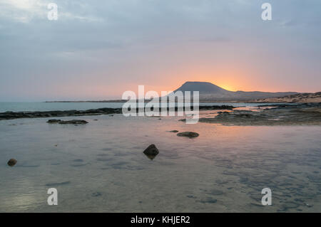 view of Playa del Salado at sunset with Monaña Amarilla in the background, La Graciosa, Canary Islands, Spain Stock Photo
