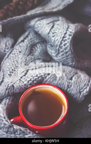 Winter background - hot tea in red cup and gray woolen scarf Stock Photo