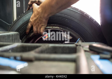 Technician work with mechanic balancing wheel. Motion blurred shot Stock Photo