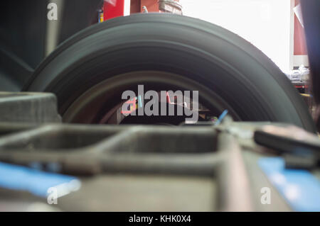 Tyre spinning at mechanic balancing wheel. Motion blurred shot Stock Photo