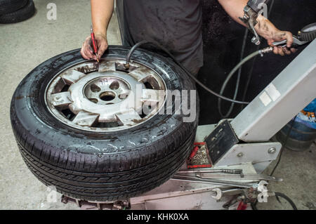 Car repairman hands checking the tyre pressure. Motion blurred shot Stock Photo