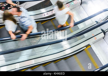 People on Escalator Motion Blurred, Top View. Abstract Blur Background of Moving Staircase Stock Photo
