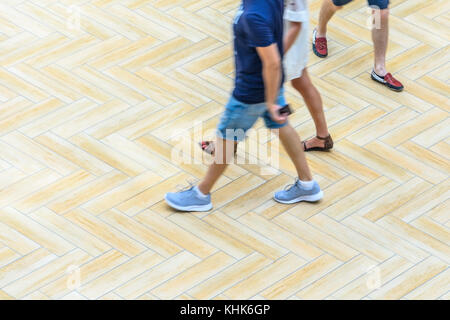 Silhouettes of Walking People in the Atrium of a Large Public Building, View from Above. Blur in Motion, Long Exposure. Abstract Background Stock Photo