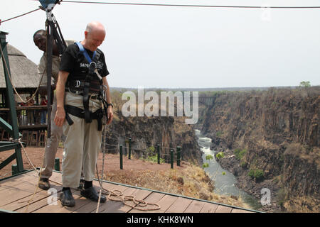 VICTORIA FALLS, ZIMBABWE - 20 October 2011. A tourist gets strapped for a zip wire glide over The Zambezi river gouge. The gouge  also marks the borders between Zimbabwe and Zambia. . Credit: David Mbiyu/Alamy Live News Stock Photo
