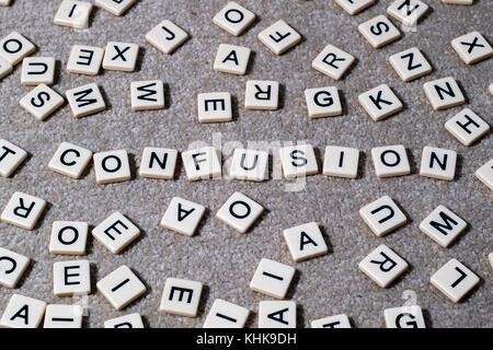 Confusion spelled out on scrabble style lettered tiles amongst a jumble of other letters. Stock Photo