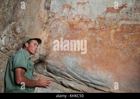MATOPO, ZIMBABWE -  17 October. Game ranger Ian Harmer talks to tourists about bushmen rock painting in the Nswatugi Cave in the Matobo National Park. Credit: David Mbiyu/Alamy Live News Stock Photo