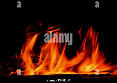 Red and orange spurts of flame and coal from the bonfire on a black background Stock Photo