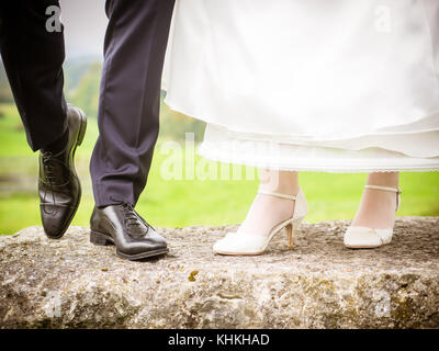 Bride and groom show their shoes Stock Photo