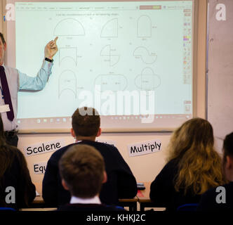 Secondary Education in the UK: Pupils looking at a teacher explaining geometry priciples using a white board in a mathematics class lesson Stock Photo