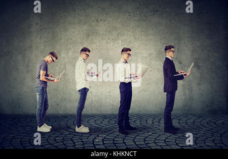 Young man with laptop computer growing older, succeeding in his career Stock Photo