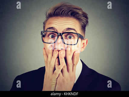 Portrait of a young anxious man looking shocked scared looking at camera Stock Photo