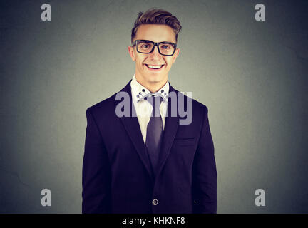 Laughing funny looking handsome businessman in glasses on gray wall background Stock Photo