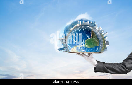 Hand of waitress presenting Earth globe on tray. Stock Photo