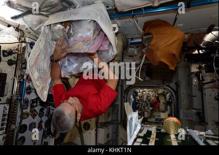 Expedition 53 Italian astronaut Paolo Nespoli works upside down on organizing cargo storage aboard the International Space Station November 17, 2017 in Earth Orbit. Stock Photo