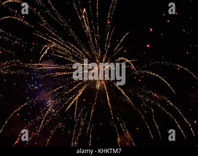 Explosion of yellow fireworks against the background of a dark night sky Stock Photo