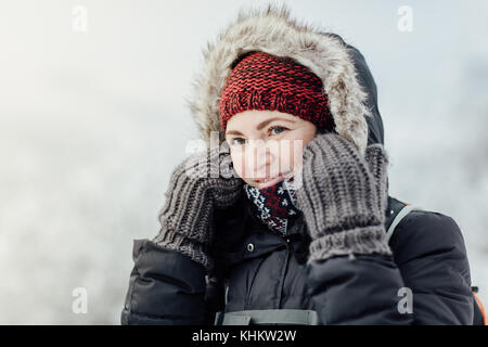 Portrait of a happy female tourist putting a hood on Stock Photo