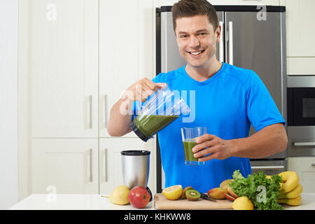 Male Athlete Making Juice Or Smoothie In Kitchen Stock Photo