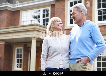 Smiling Mature Couple Standing Outside Home Stock Photo